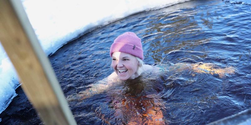 Frau beim Eisbaden im See in Finnland