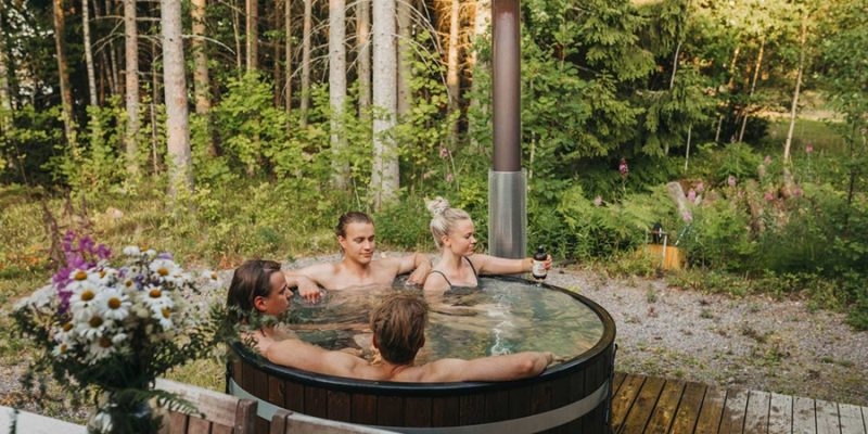 Gruppe entspannt draussen im Whirlpool in Skandinavien