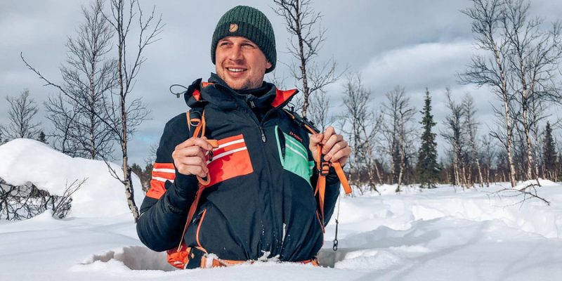 Mann im Schneeanzug im Winter in Lappland