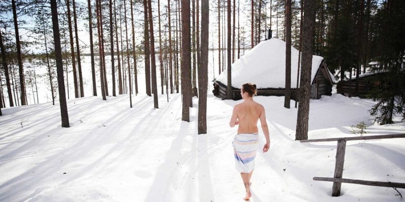 Man läuft nach der Sauna im Schnee im Wald