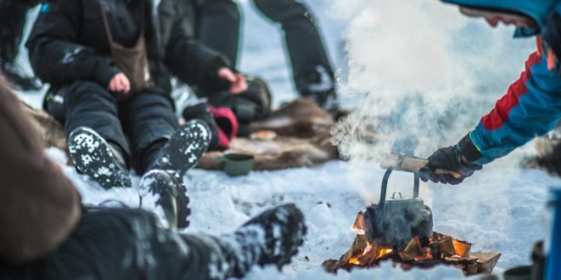Eine Gruppe von Menschen am Lagerfeuer im Winter