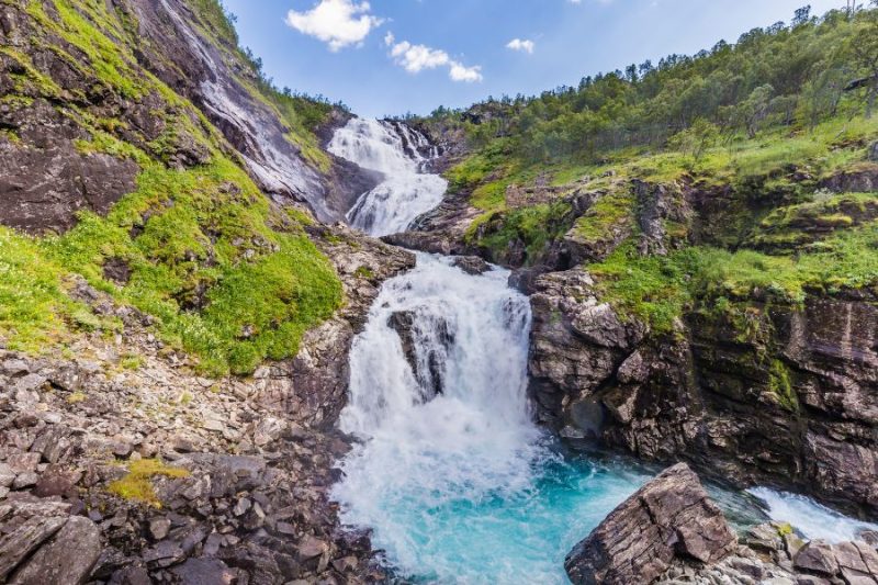 Kjosfossen-Wasserfall-waehrend-Zugfahrt-Flamsbana-in-Norwegen